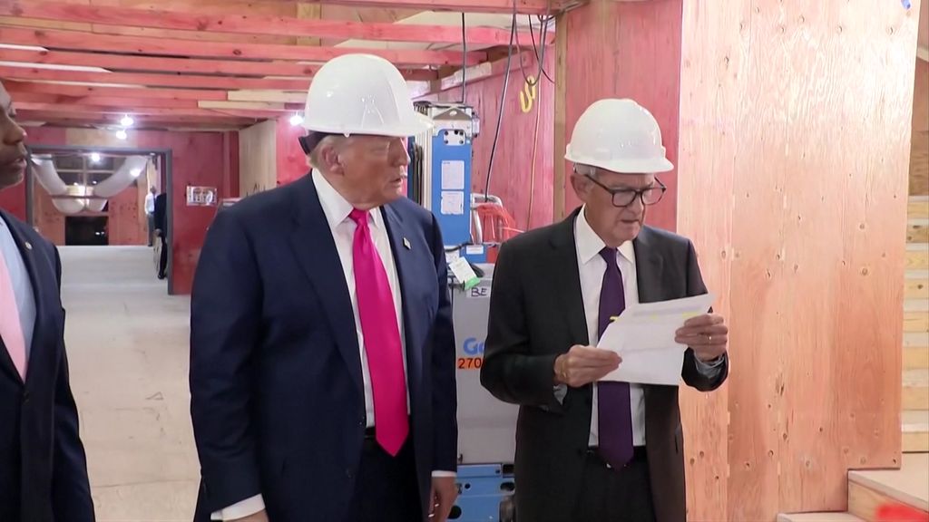 Trump and Powell looking a sheet of paper