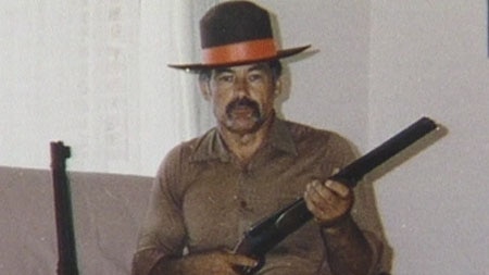 A young Ivan Milat holds a shotgun.