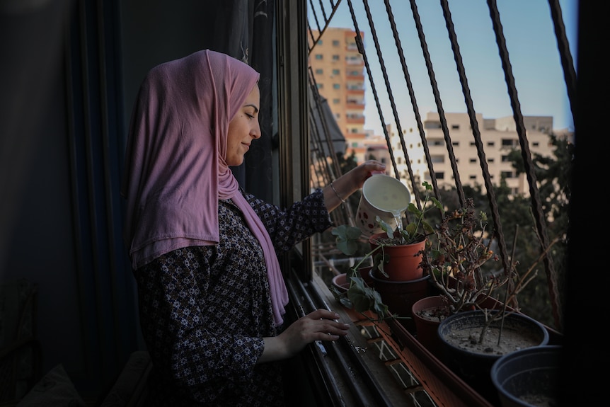 Bisan Shrafi waters her plants. 