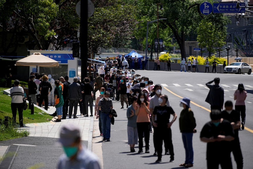 Residents line up for nucleic acid tests on a street. 