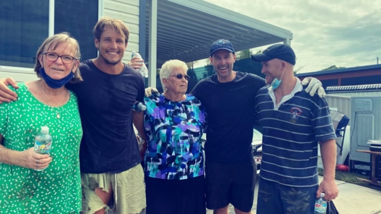 Five people post for a photo in front of a house in northern new south wales after the flooding. 