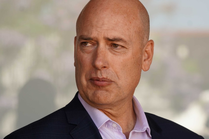 A close up of Dean Nalder's face, looking pensive, away from the camera.