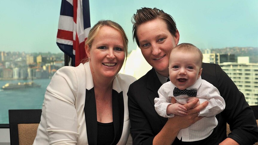 Amanda, Amy and their child have a photo taken together.