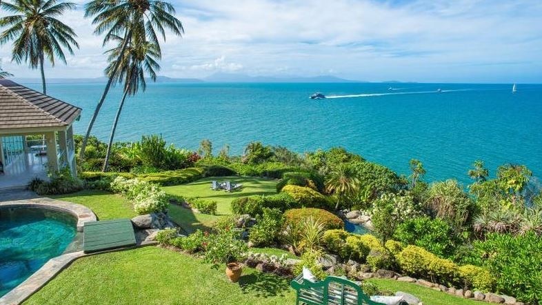 The spectacular view from a home perched on a hill overlooking the ocean with a catamaran crossing the water about 500m away  