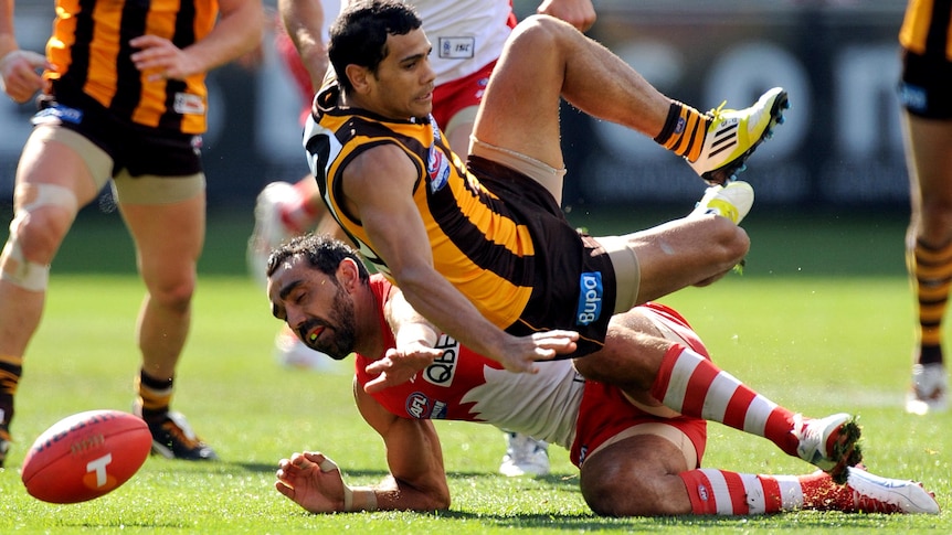 Cyril Rioli of Hawthorn and Adam Goodes of Sydney contest for the ball.