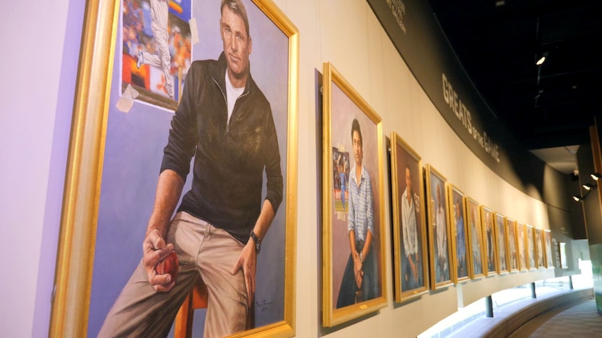 A painting of Shane Warne sits on a wall with other portraits