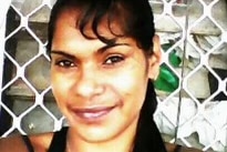 A medium close-up of a smiling woman with black hair and a black singlet