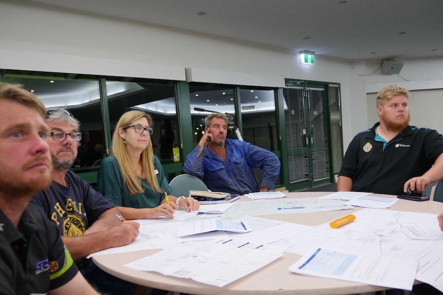 People sit around a table at a community meeting in the town of Katanning.