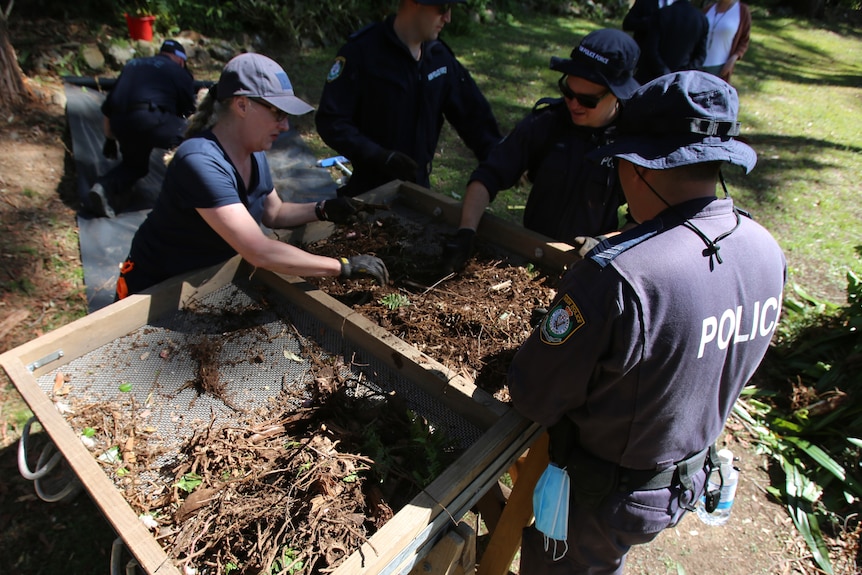 Police officers digging for evidence