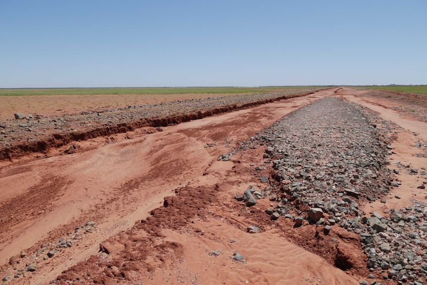 An eroded road of red dirt