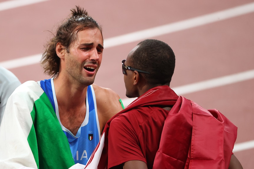 A tearful Italian high jumper talks to his rival from Qatar after they agree to share a gold medal.