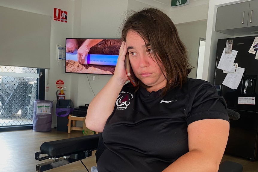 a woman in a wheelchair holds a phone to her ear