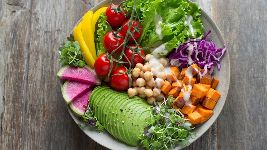 A bowl of brightly coloured vegetables with avocado and chickpeas