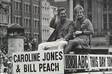 Bill Peach and Caroline Jones on a This Day Tonight car waving to crowd during parade.
