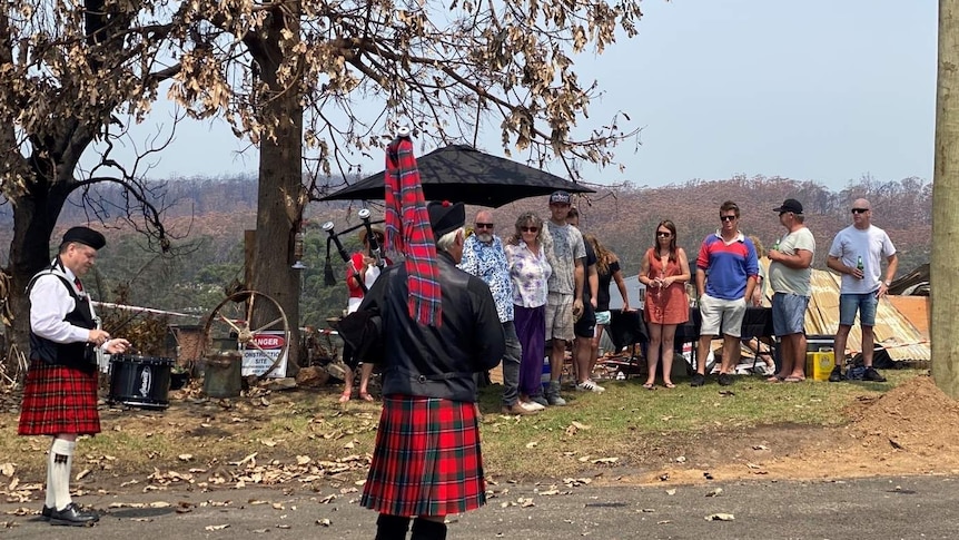 A man playing bagpipes in front of people