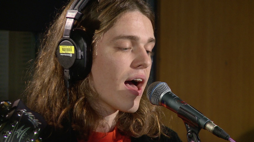 A photo of Allday doing a live performance of 'Never Tear Us Apart' in the triple j studios