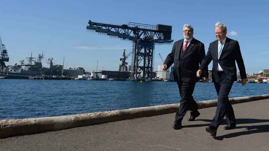 Kevin Rudd and Kim Carr walk to a press conference near Garden Island naval base