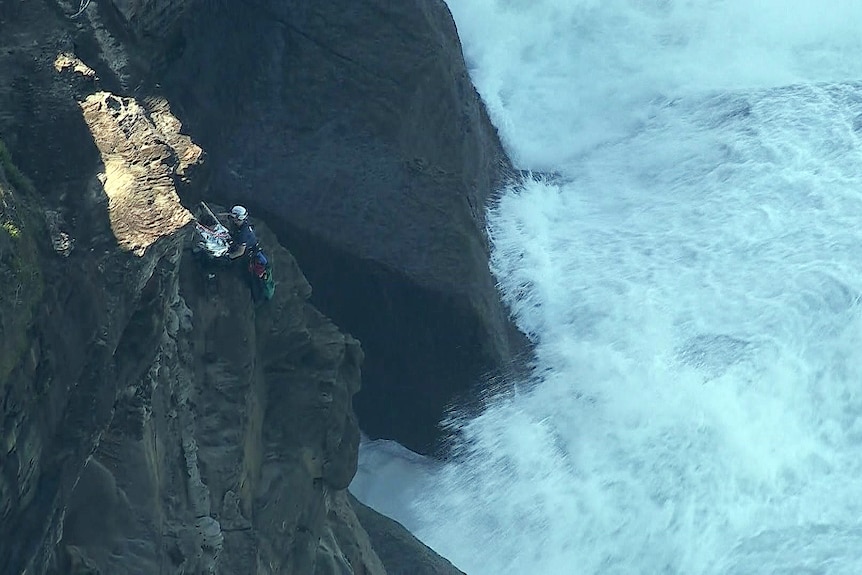 a paramedic rescues a man from a side of a cliff at the royal national park south of sydney after he fell 20 metres 