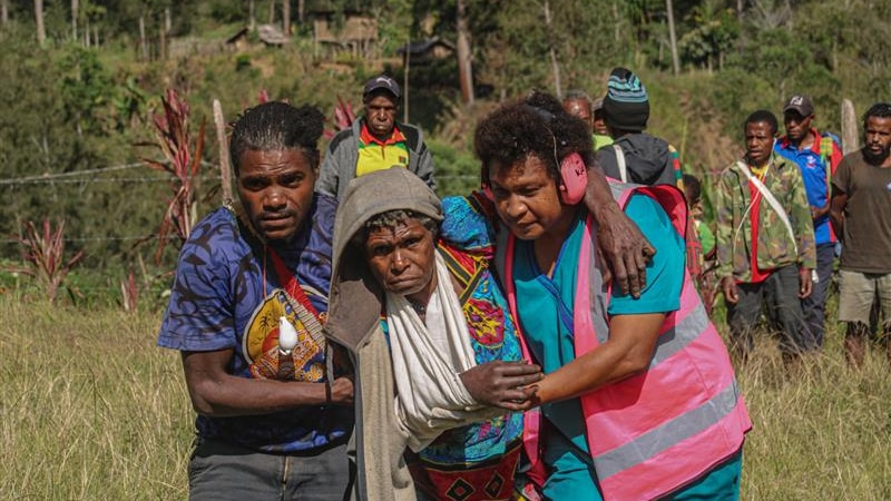 Woman with arm in sling help by man and women.