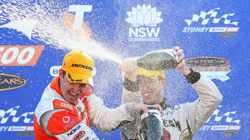 Victory shower: Courtney (r) showers champion Jamie Whincup after the final race.