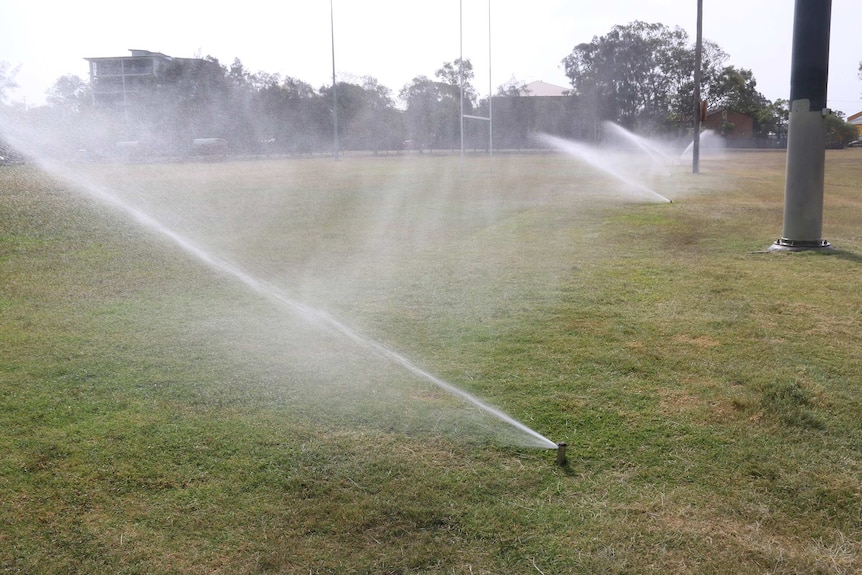 Half a dozen sprinklers water fields at Mitchelton Soccer Club's grounds.