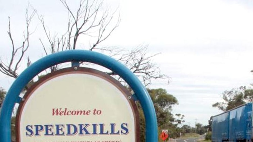 A truck passes be a new speed kills sign on the outskirts of a town in Victoria