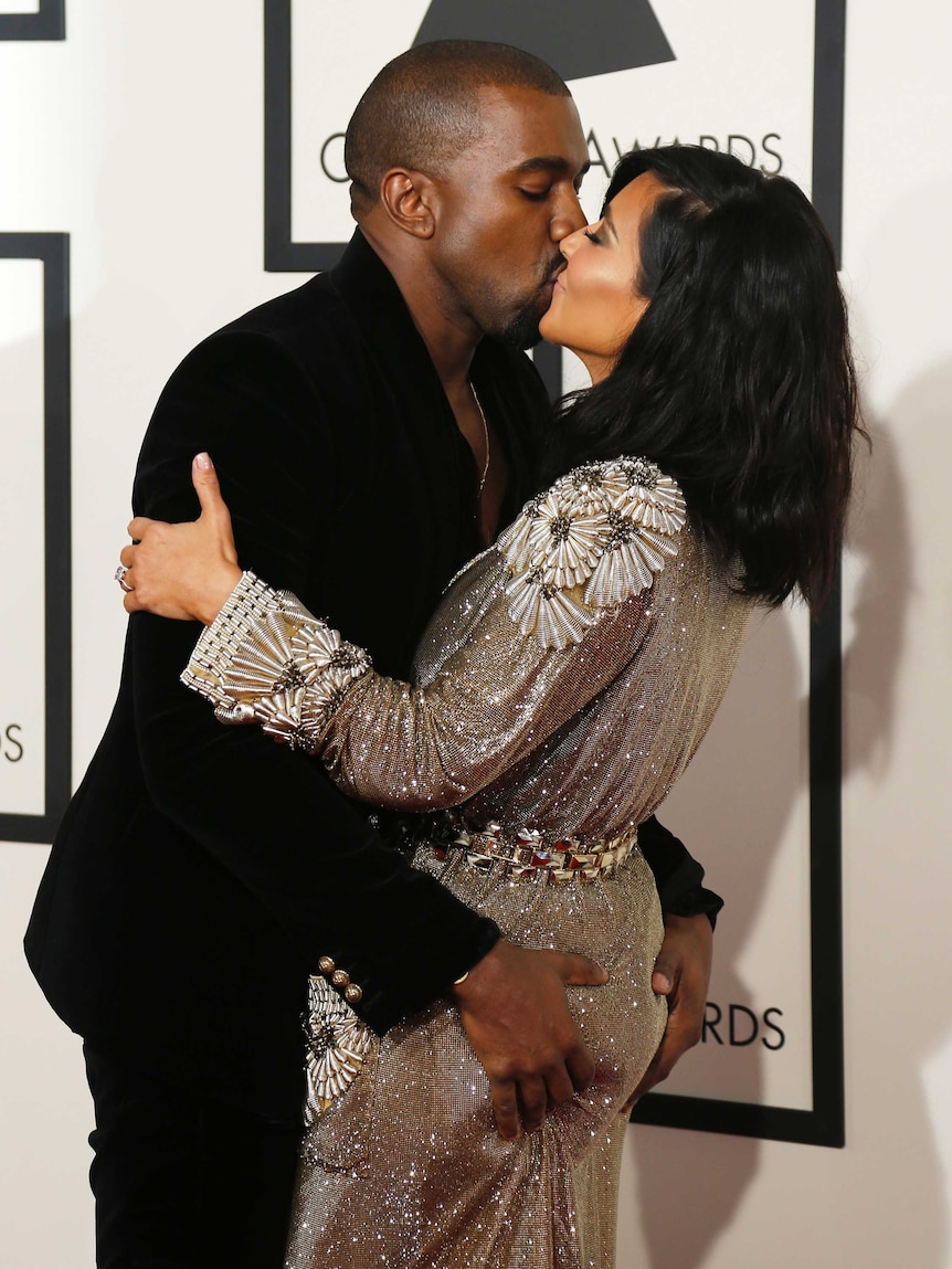 Kanye West and Kim Kardashian kiss for the cameras