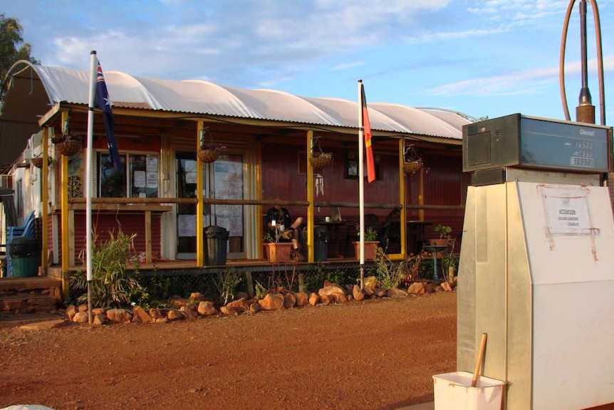 A small roadhouse on red gravel with tin roof