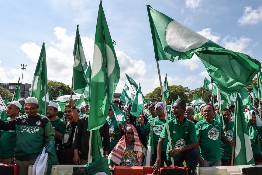 Supporters of Pan-Malaysia Islamic party gather with green clothing and flags in Pekan.