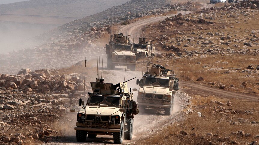 A convoy of armoured vehicles drive outside Naweran near Mosul in Iraq.