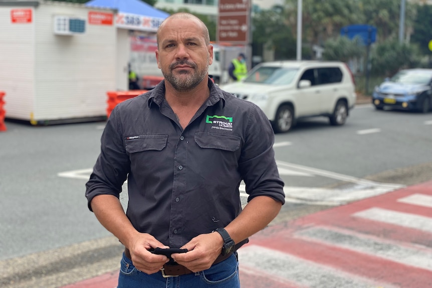 A man stands at a border checkpoint on the Gold Coast