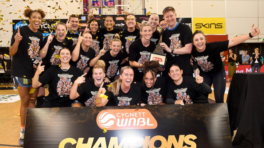 Townsville Fire pose for a team photo with the trophy.