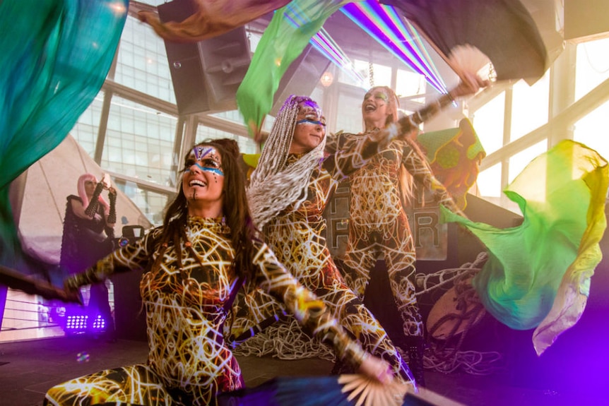 Dancers in colourful outfits performing on the floor.