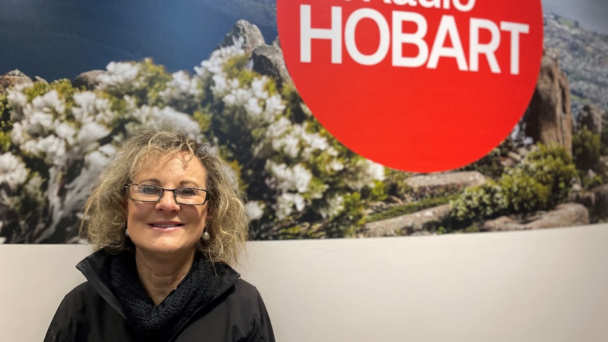 Woman stands in front of ABC Radio Hobart sign