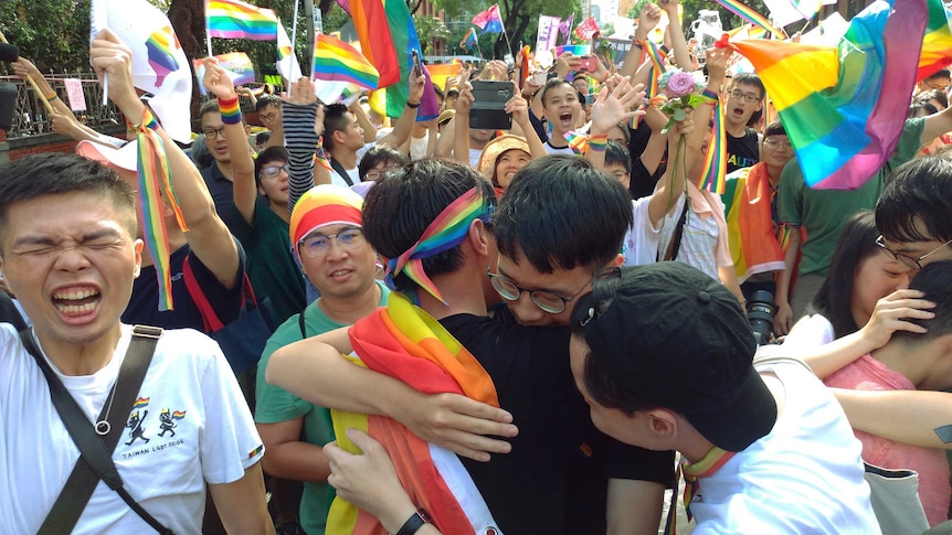 Taiwanese same-sex marriage supporters hug each other while the crowd celebrating the long-awaited same-sex marriage legislation