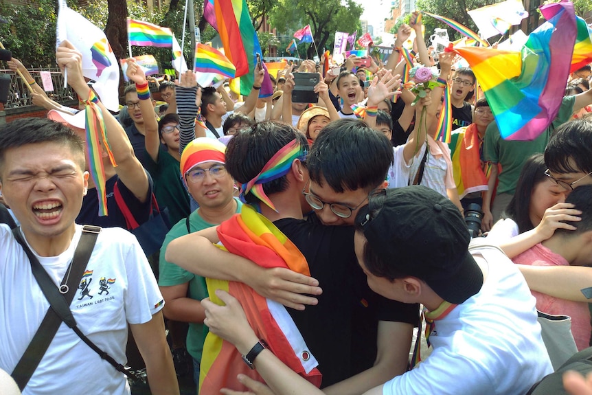 Taiwanese same-sex marriage supporters hug each other while the crowd celebrating the long-awaited same-sex marriage legislation