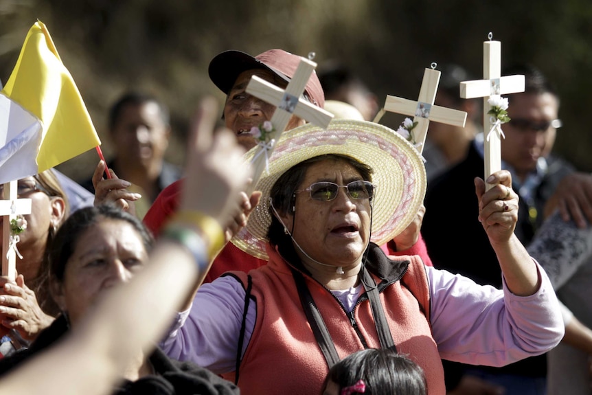 Catholic faithful wait for Pope Francis to drive past in Quito, Ecuador