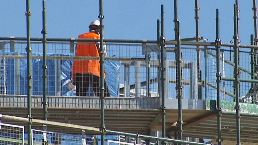 An unidentified construction worker on scaffolding on an apartment construction site in Canberra