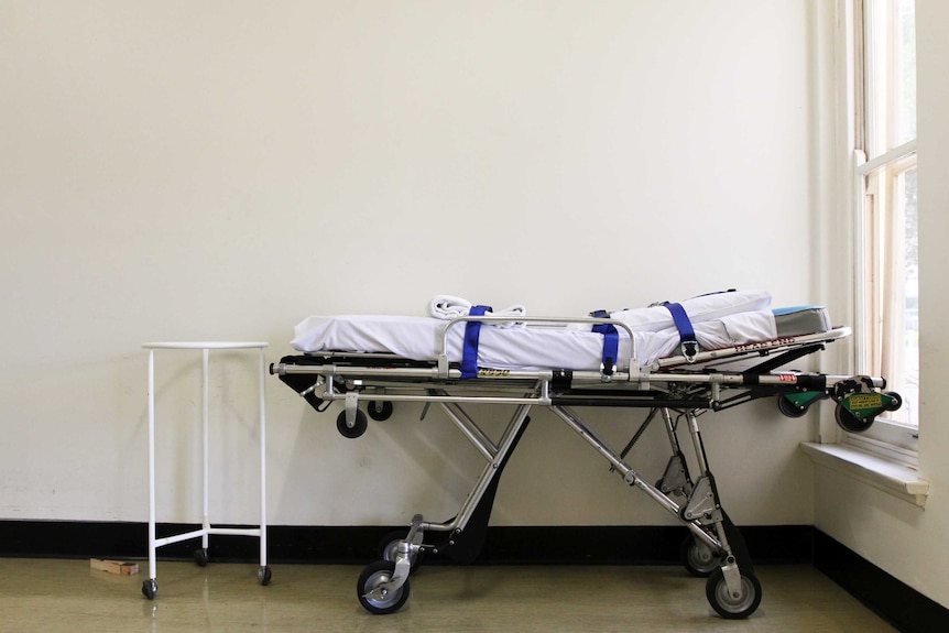 Empty bed in hospital corridor.