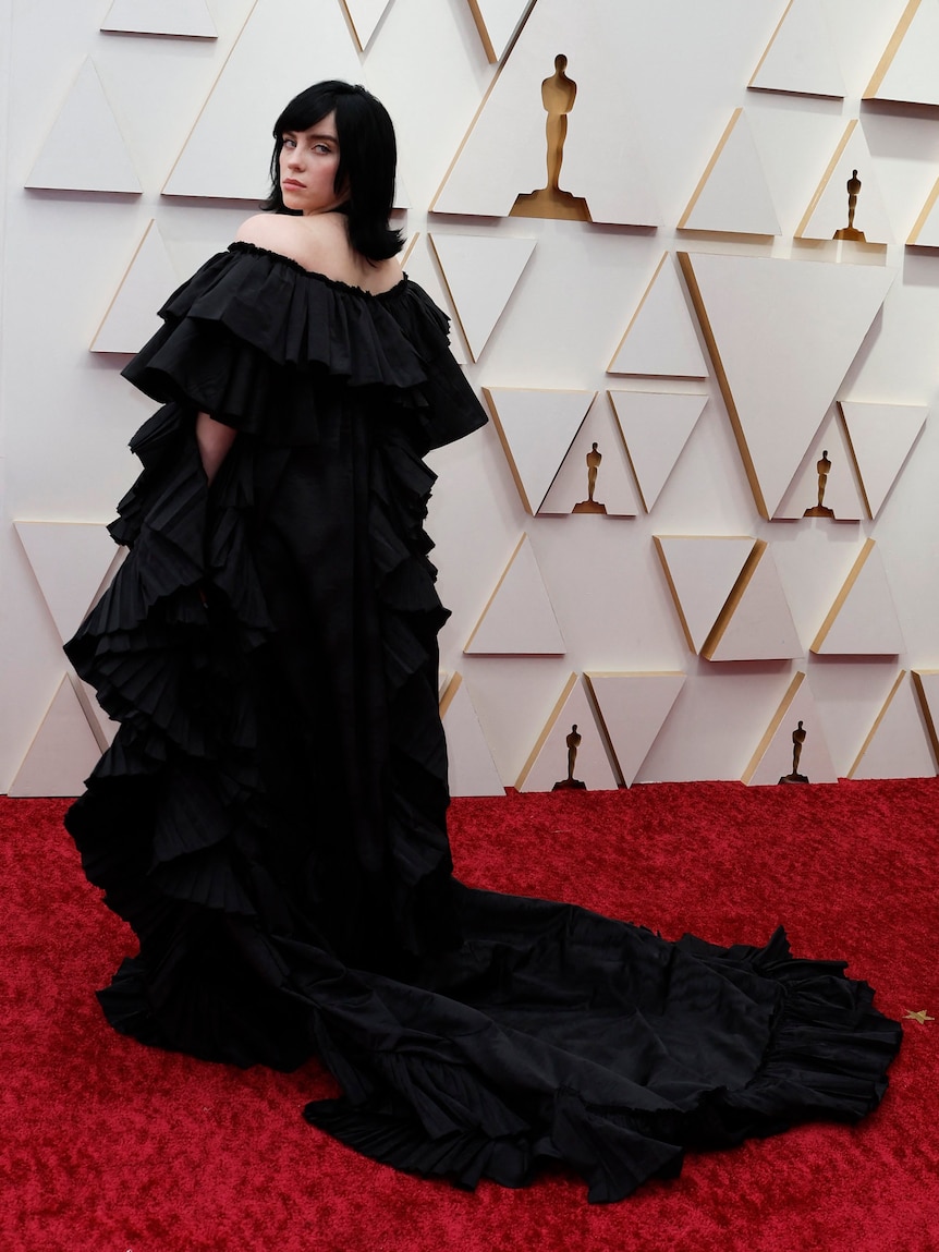 musician billie eilish wears a large ruffled black off-the-shoulder gown on the red carpet