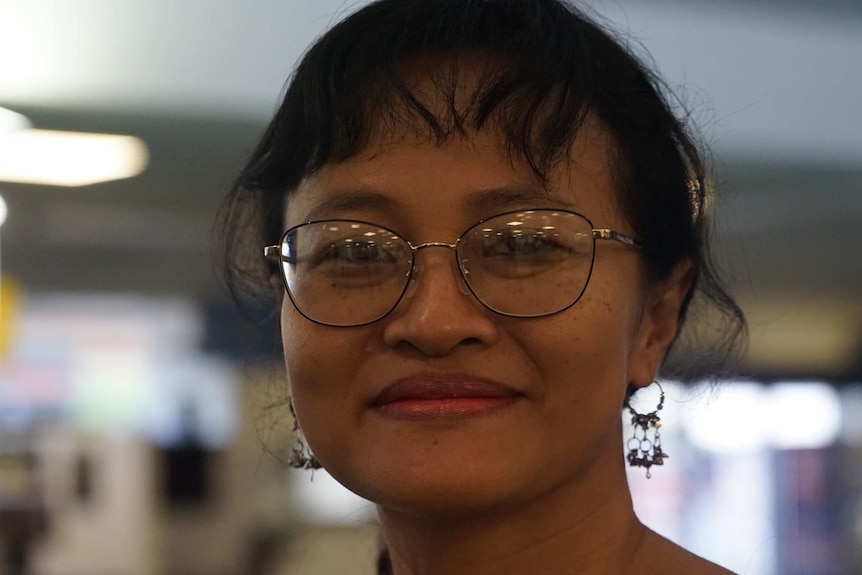 Wulan Morling looks at the camera from close distance wearing glasses at the Darwin Airport.
