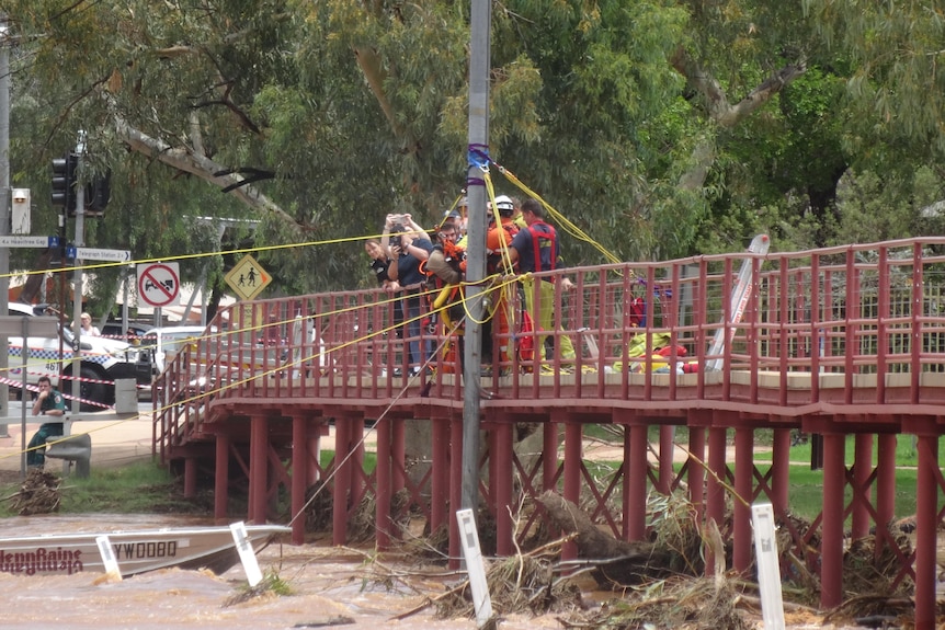 Man pulled over bridge from floodwater below.