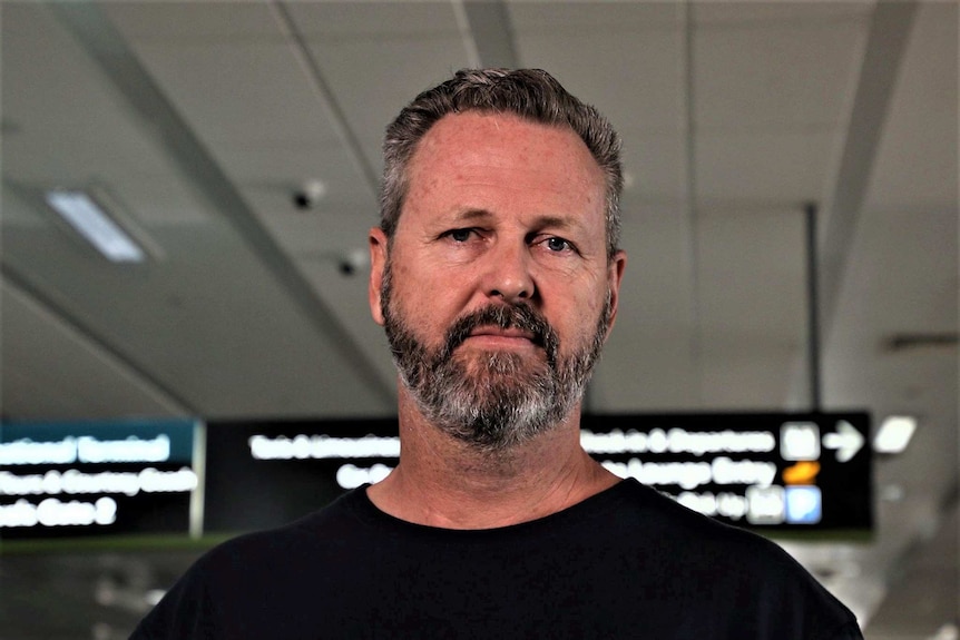 Mark Wallace standing in an airport arrival hall