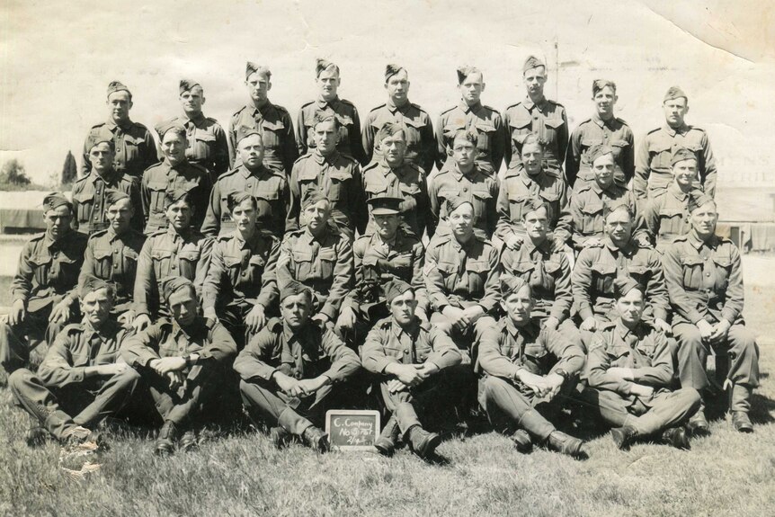 An old photo from WWI featuring four rows of men in military uniform.