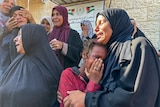 A group of women hugging each other and crying. 