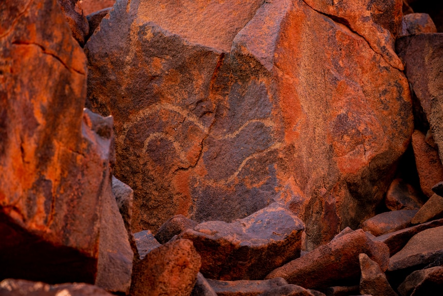 Indigenous rock art depicting a snake, painted on a large rock face