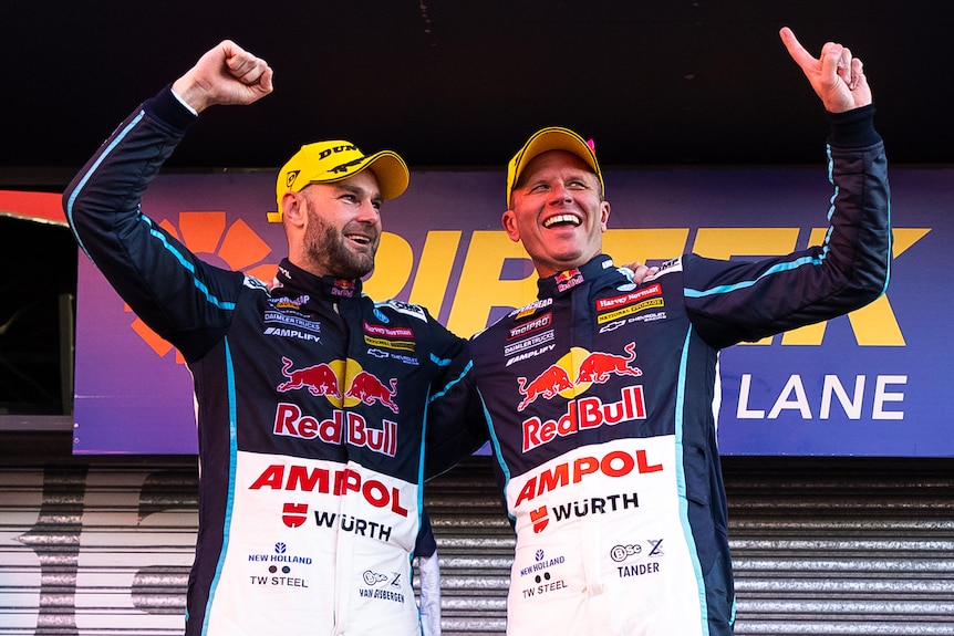 Shane van Gisbergen and Garth Tander stand together pointing their fingers in celebration.