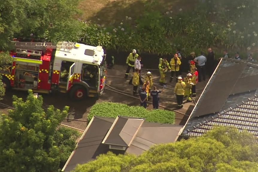 Aerial image of firefighters standing out the front of house of Grose Vale, north of Sydney
