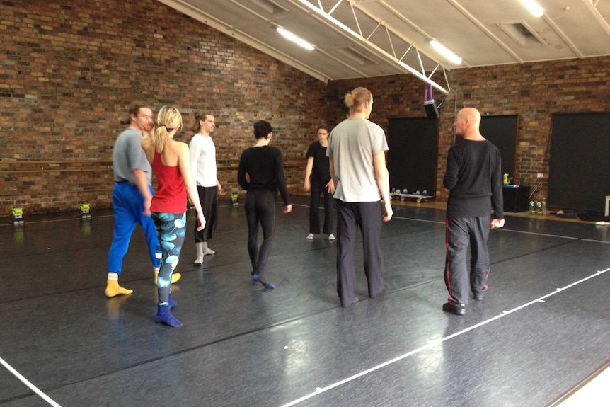 Choreographer Graeme Murphy (far right) speaks with dancers at a rehearsal for Affinity.