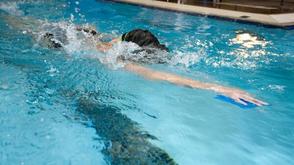 A person swimming laps in a pool.